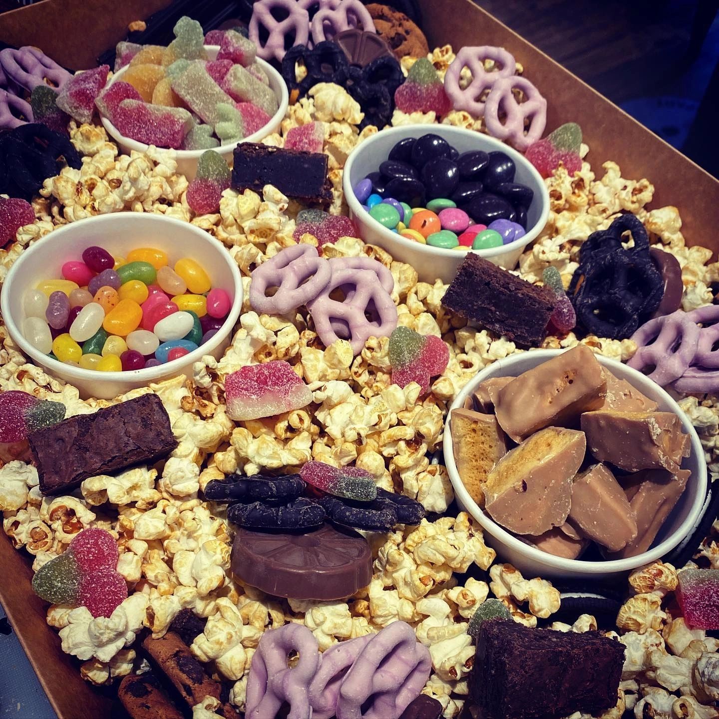 A grazing tray of popcorn, sweets and brownies