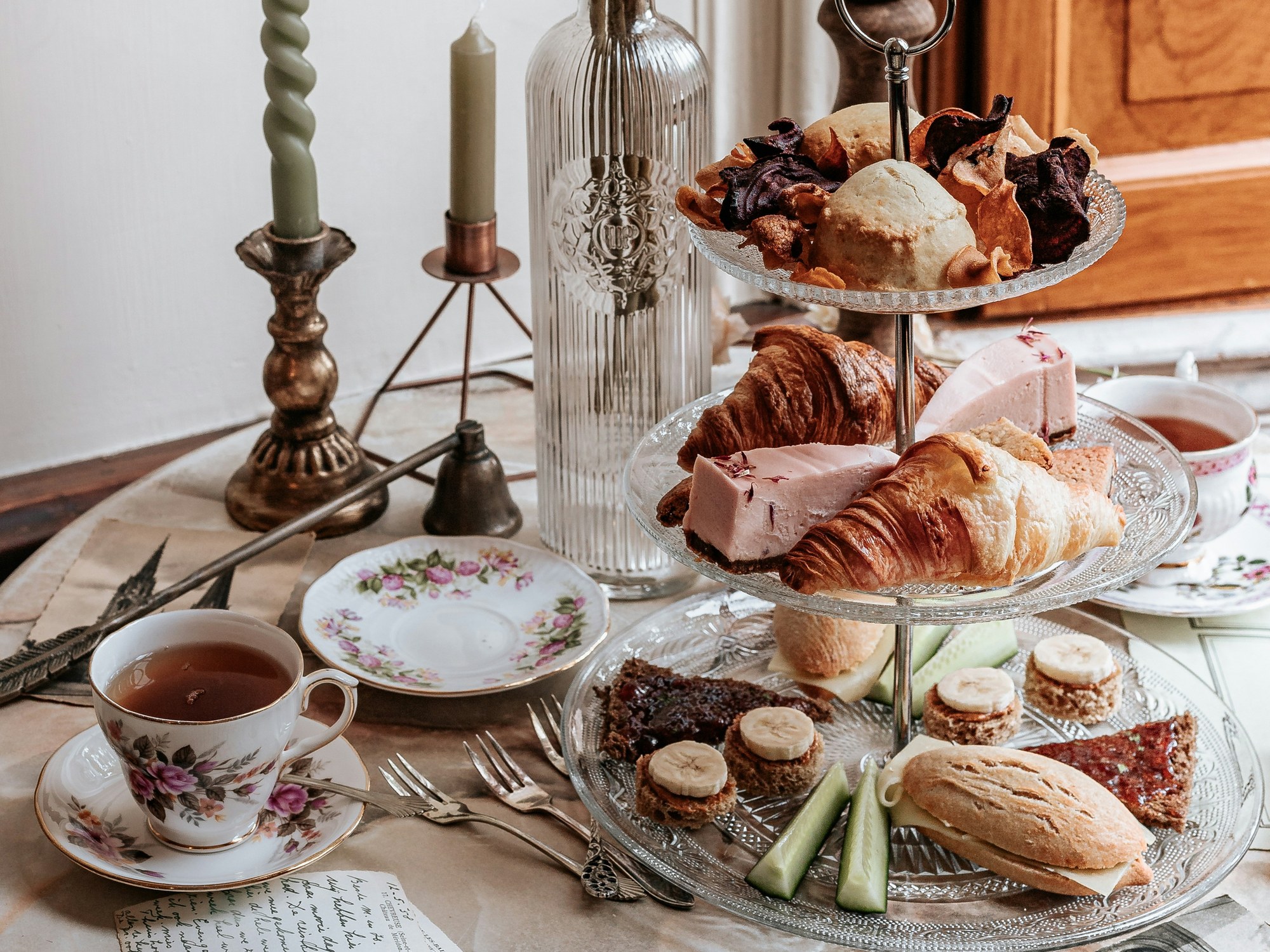 A table set for afternoon tea with a tiered stand and teacup
